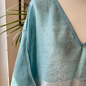 May include: A light blue linen top with a V-neck and a pink and white striped bottom.