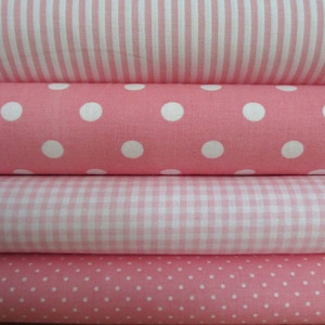 Pode incluir: Quatro rolos de tecido rosa com padrões diferentes: listras, bolinhas grandes, xadrez e bolinhas pequenas.