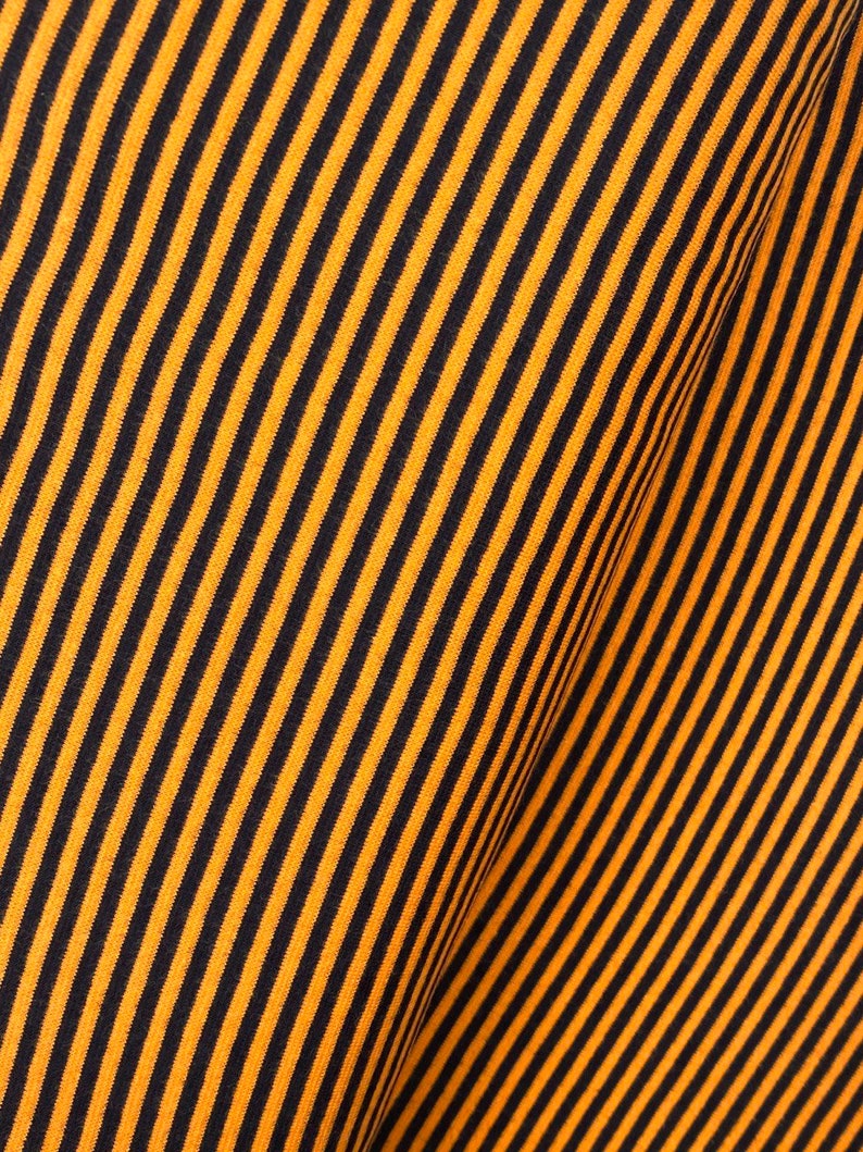 May include: Orange and black striped fabric with a diagonal pattern.