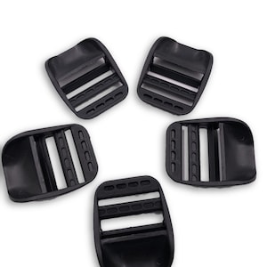 Puede incluir: Cinco hebillas deslizantes de plástico negro. Las hebillas tienen tres ranuras y están diseñadas para usarse con correas o cintas.