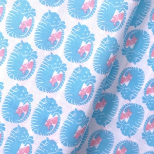 Könnte beinhalten: Weißer Stoff mit einem sich wiederholenden Muster aus blauen und rosa Katzen, die sich im Kreis zusammenrollen.