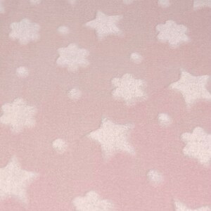 Könnte beinhalten: Ein rosa Stoff mit einem weißen Sternen- und Wolkenmuster.