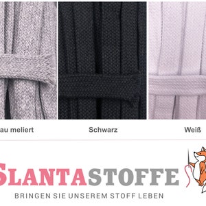 Könnte beinhalten: Nahaufnahme von drei Stoffmustern: grau, schwarz und weiß. Jedes Muster ist eine dicke, geflochtene Kordel mit einem passenden Band darum. Die Texte "Grau meliert", "Schwarz" und "Weiß" stehen darunter. Das Logo von "SLANTASTOFFE" befindet sich unten.