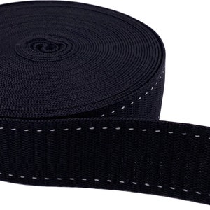 May include: Black webbing with white stitching. The webbing is rolled up and the stitching is visible on the edge.