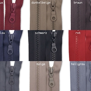 Könnte beinhalten: Eine Auswahl an Reißverschlussbändern in verschiedenen Farben, darunter Burgunder, Beige, Braun, Dunkelblau, Schwarz, Rot, Grau und Hellgrau. Die Reißverschlüsse sind alle geschlossen und haben einen schwarzen Schieber.
