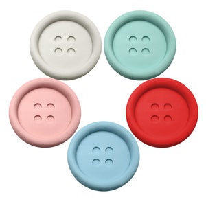 Könnte beinhalten: Fünf runde Silikon-Untersetzer in verschiedenen Farben: hellgrau, hellblau, hellgrün, rosa und rot. Jeder Untersetzer hat ein erhabenes Knopfdesign mit vier Löchern.