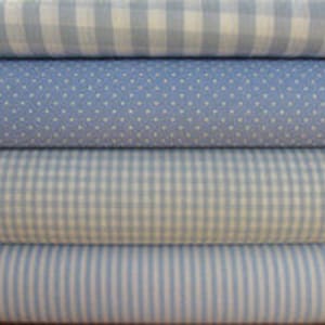 Könnte beinhalten: Vier Rollen blauer und weißer gemusterter Stoff. Die Stoffmuster umfassen Gingham, Punkte und Streifen.