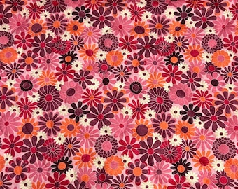 May include: Pink fabric with a repeating pattern of colorful flowers. The flowers are in shades of pink, orange, and purple.