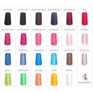 Könnte beinhalten: Ein Raster farbiger Garnspulen, jede mit einem deutschen Farbnamen beschriftet. Zu den Farben gehören Schwarz, Dunkelbraun, Rot, Rosa, Blau, Grün, Orange und Gelb. Die Spulen sind in Reihen und Spalten angeordnet.