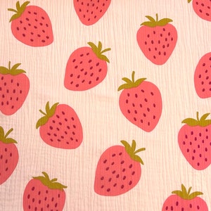 Peut inclure: Un tissu rose et blanc avec un motif répété de fraises roses. Les fraises ont une tige et des feuilles vertes.