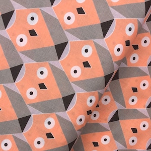 Puede incluir: Un patrón repetido de formas geométricas en tonos melocotón, gris y negro. El patrón presenta círculos, diamantes y triángulos.