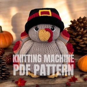 May include: A knitted turkey doll wearing a black hat with red and yellow accents. The turkey has a yellow beak and red wattle. The text "KNITTING MACHINE PDF PATTERN" is displayed on the front of the turkey. Pumpkins and pinecones are in the background.