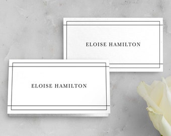 May include: Two white place cards with black borders and the name "Eloise Hamilton" printed on each.