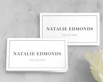 May include: Two white place cards with black borders and text. The top card reads "Natalie Edmonds Table | Three". The bottom card reads "Natalie Edmonds Table | Three".
