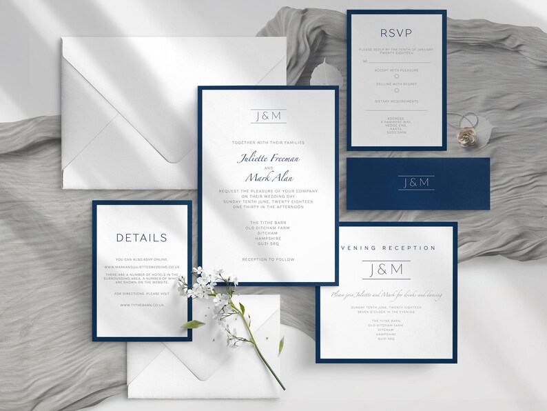 May include: A collection of elegant wedding stationery featuring a navy blue and white color scheme. The set includes invitations, RSVP cards, details cards, and envelopes. The invitations display the names "Juliette Freeman and Mark Alan".