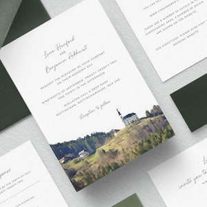 May include: Wedding invitation with a watercolor illustration of a church on a hill with green trees. The invitation is for Luna Hanford and Benjamin Ackhurst, and the wedding will be held on September 19th, 2022 at Wollaton Hall & Deer Park in Nottingham, England.