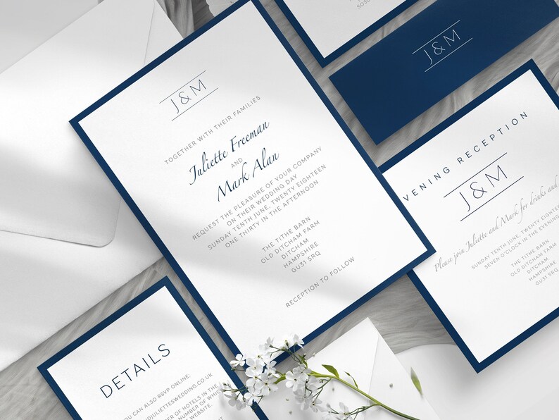May include: Elegant wedding invitation suite featuring white cards with navy blue borders. The invitations include the initials "J&M" and event details. A matching navy blue envelope is also included.