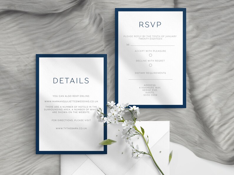 May include: Navy blue and white wedding invitation suite. The suite includes an RSVP card and a details card, both with navy blue borders and elegant typography. The RSVP card includes fields for the guest's name, acceptance, and dietary requirements. The details card provides website information.