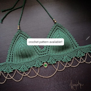 Puede incluir: Un top de crochet verde con ribete de cadena dorada y un colgante de piedra preciosa verde. El texto "crochet pattern available!" está escrito en la imagen.