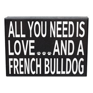 May include: Black wooden sign with white text that reads "All you need is love... and a French Bulldog".