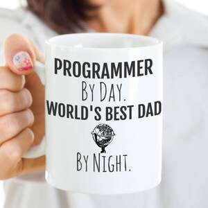 May include: White ceramic mug with black text that reads "Programmer by day. World's best dad by night."
