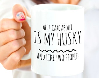 May include: White ceramic mug with black text that reads "All I care about is my husky and like two people".
