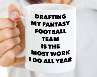 May include: White ceramic coffee mug with black text that reads "Drafting my fantasy football team is the most work I do all year".
