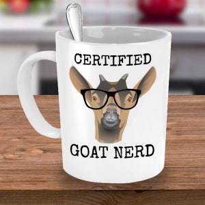 May include: White ceramic coffee mug with a black and white illustration of a goat wearing glasses. The text "CERTIFIED GOAT NERD" is printed on the mug.