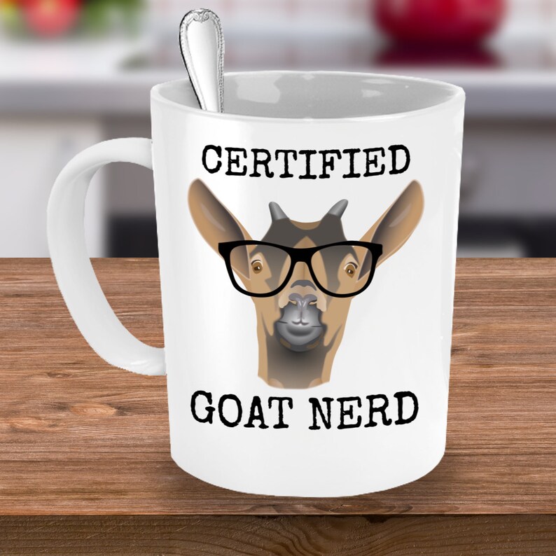 May include: White ceramic coffee mug with a black and white illustration of a goat wearing glasses. The text "CERTIFIED GOAT NERD" is printed on the mug.
