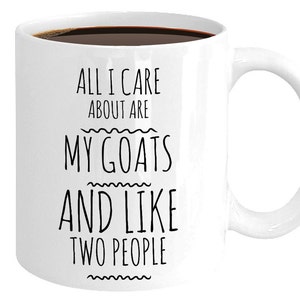 Peut inclure: Une tasse &agrave; caf&eacute; en c&eacute;ramique blanche avec du texte noir qui dit "All I care about are my goats and like two people".