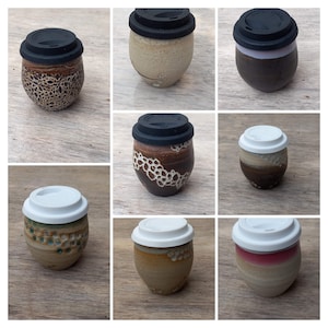 May include: Ten ceramic to-go mugs with black and white lids. The mugs are in various colors and patterns, including brown, white, and beige. Some mugs have a speckled pattern, while others have a more solid color.
