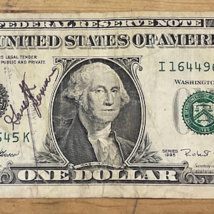 May include: A one dollar bill with the serial number I16449645K. The bill is signed by Robert E. Rubin, Secretary of the Treasury, and Mary Ellen Withrow, Treasurer of the United States. The bill is also signed by a person with the name "Jeff" and another person with the name "Ray Allen".