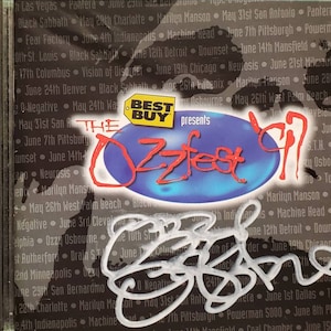May include: A blue and white circular design with the text "The Ozzfest 97" in red and white. The text "Best Buy presents" is in black and white. The image also includes a list of dates and locations for the Ozzfest tour.