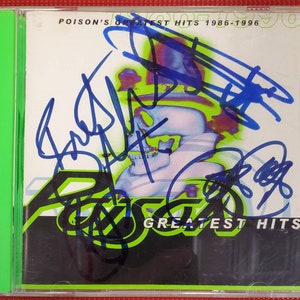 May include: A CD case with a green spine and a black and white image of a skull with a green and black background. The text "POISON'S GREATEST HITS 1986-1996" is printed in white on the top of the case. The text "GREATEST HITS" is printed in white on the bottom of the case. The case is signed by the band members in black and blue ink.