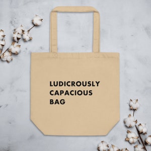 May include: A beige canvas tote bag with black text that reads "Ludicrously Capacious Bag".