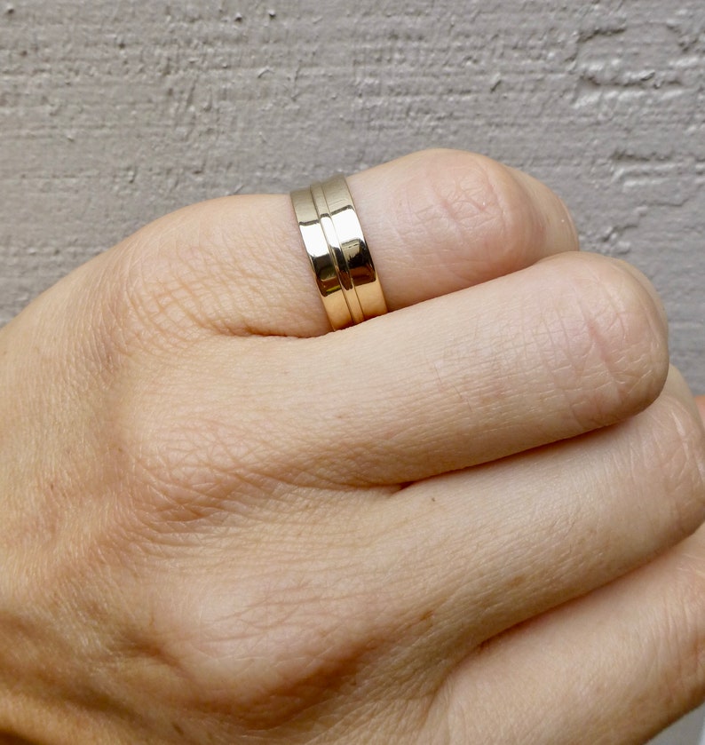 May include: A gold band ring with a double groove design.
