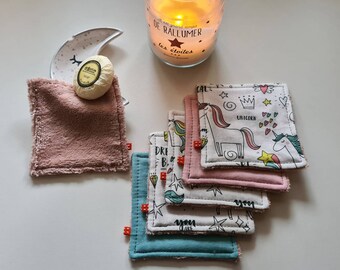以下が含まれることがあります： ユニコーンと星のデザインが様々な、カラフルなコットン製のメイク落としパッド6枚セット。パッドは重ねて置かれており、柔らかくふわふわとした質感です。