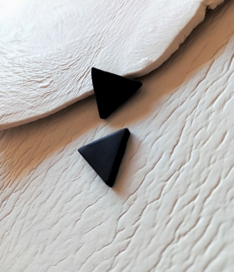 Triangle stud earrings handmade from matte black polymer clay by Vertseas.