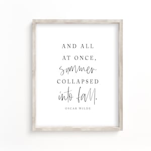 May include: A framed print with a white background and black text that reads "And all at once, summer collapsed into fall."  The text is in a handwritten font.  The quote is attributed to Oscar Wilde at the bottom of the print.