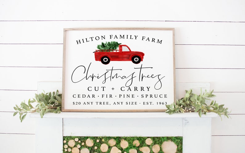 May include: A white sign with a red truck carrying a Christmas tree. The sign reads "HILTON FAMILY FARM Christmas Trees CUT + CARRY CEDAR FIR PINE SPRUCE $20 ANY TREE, ANY SIZE EST. 1963".