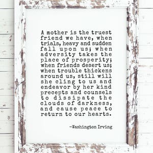 May include: A black and white image of a framed quote about the importance of a mother's love and support. The quote reads: "A mother is the truest friend we have, when trials, heavy and sudden fall upon us; when adversity takes the place of prosperity; when friends desert us; when trouble thickens around us, still will she cling to us and endeavor by her kind precepts and counsels to dissipate the clouds of darkness, and cause peace to return to our hearts." -Washington Irving