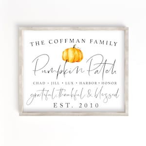 May include: A white sign with a wood frame features the text "THE COFFMAN FAMILY Pumpkin Patch grateful, thankful & blessed EST. 2010" with a watercolour illustration of a pumpkin in the centre.