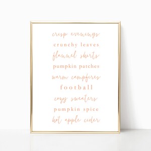 May include: A printable wall art design with a gold frame and a white background. The text reads: "crisp evenings, crunchy leaves, flannel shirts, pumpkin patches, warm campfires, football, cozy sweaters, pumpkin spice, hot apple cider".
