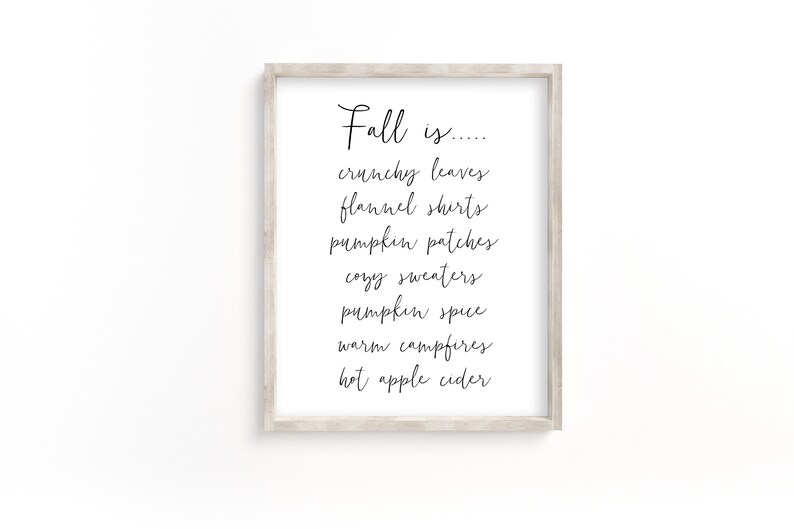 May include: A framed print with the text "Fall is..." followed by a list of fall-themed words: crunchy leaves, flannel shirts, pumpkin patches, cozy sweaters, pumpkin spice, warm campfires, and hot apple cider.