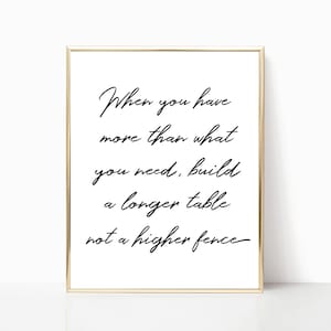 May include: A framed print with a gold border and white background. The black text reads: "When you have more than what you need, build a longer table not a higher fence."