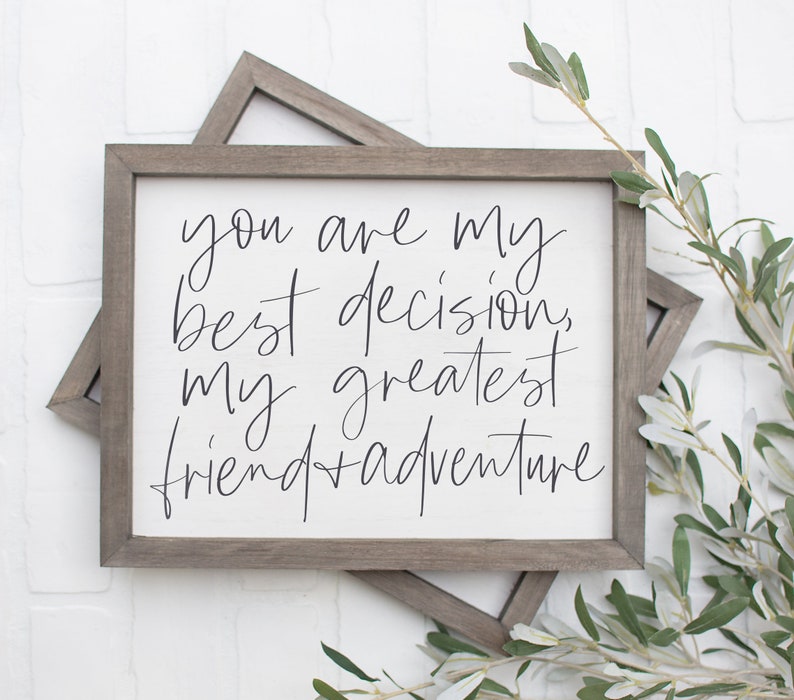 May include: A framed sign with the text "You are my best decision, my greatest friend + adventure" in black script font on a white background.