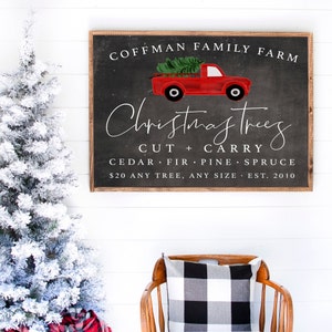 May include: A chalkboard sign with a red pickup truck carrying a Christmas tree. The sign reads "Coffman Family Farm Christmas Trees Cut + Carry Cedar Fir Pine Spruce $20 Any Tree, Any Size Est. 2010".