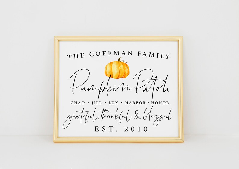 May include: A framed print with a white background and black text that reads "The Coffman Family Pumpkin Patch Chad Jill Lux Harbor Honor Grateful Thankful & Blessed Est. 2010". A watercolour painting of an orange pumpkin is above the text.