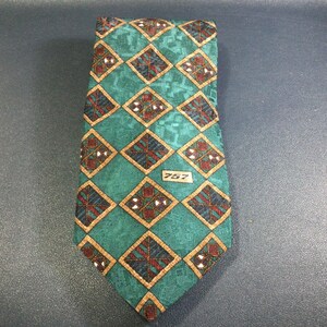 May include: A green silk tie with a geometric pattern of brown, white, and gold squares. The tie has a small label with the number "757" on it.
