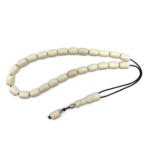 Può includere: Grani della preghiera color avorio con un cordino nero. Le perline sono rettangolari e infilate insieme. Un pezzo decorativo color avorio e una piccola perla si trovano alla fine del cordino. Le perline sono probabilmente usate per la preghiera o la meditazione.
